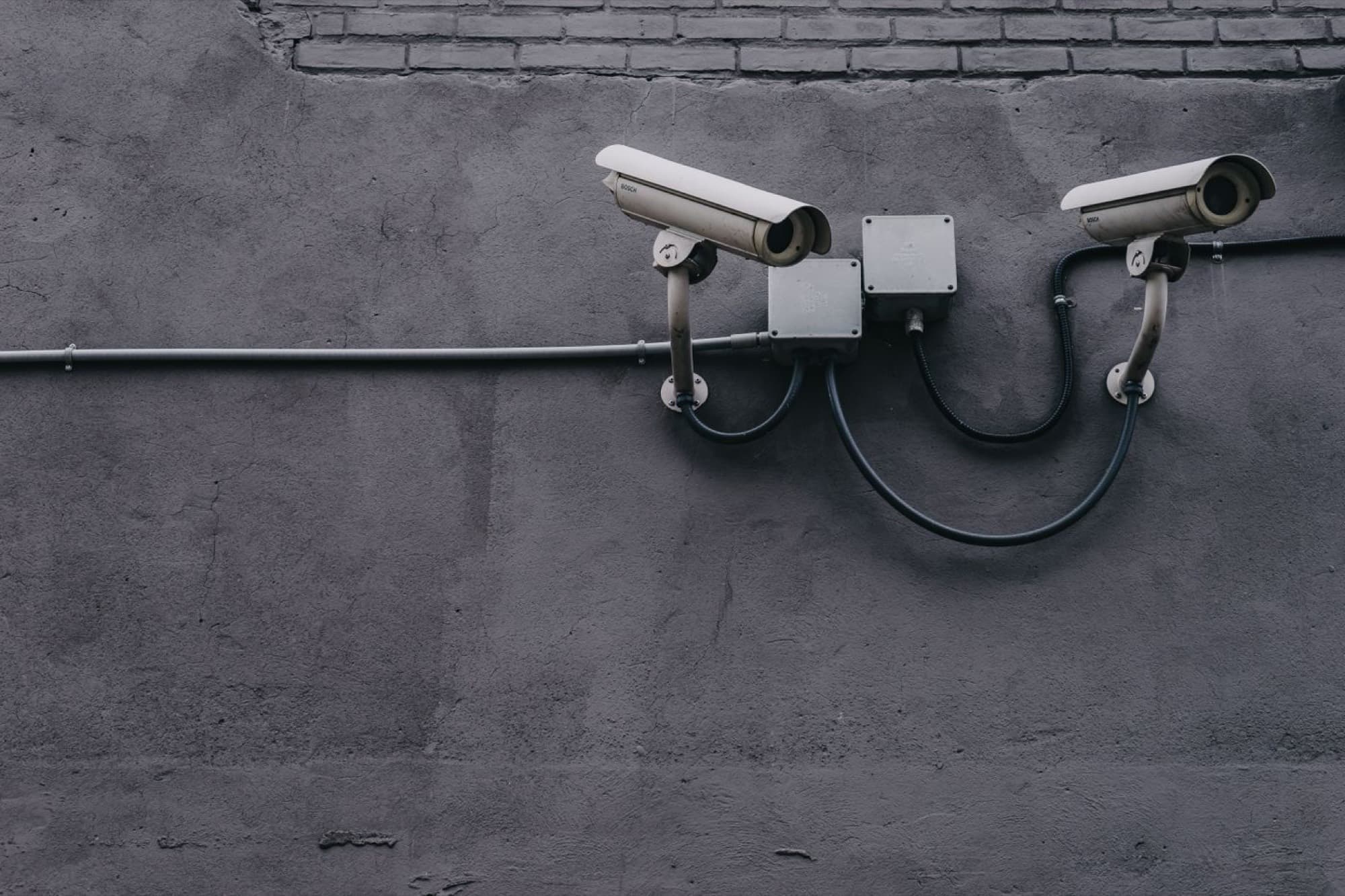 Two surveillance cameras mounted on the wall of a building