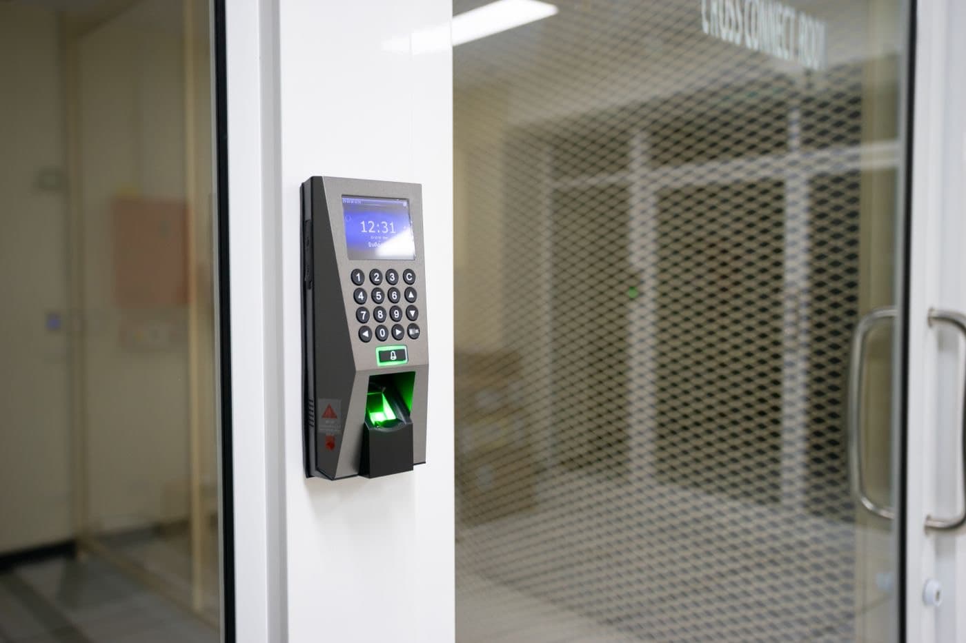 A clocking terminal on a glass door showing the time